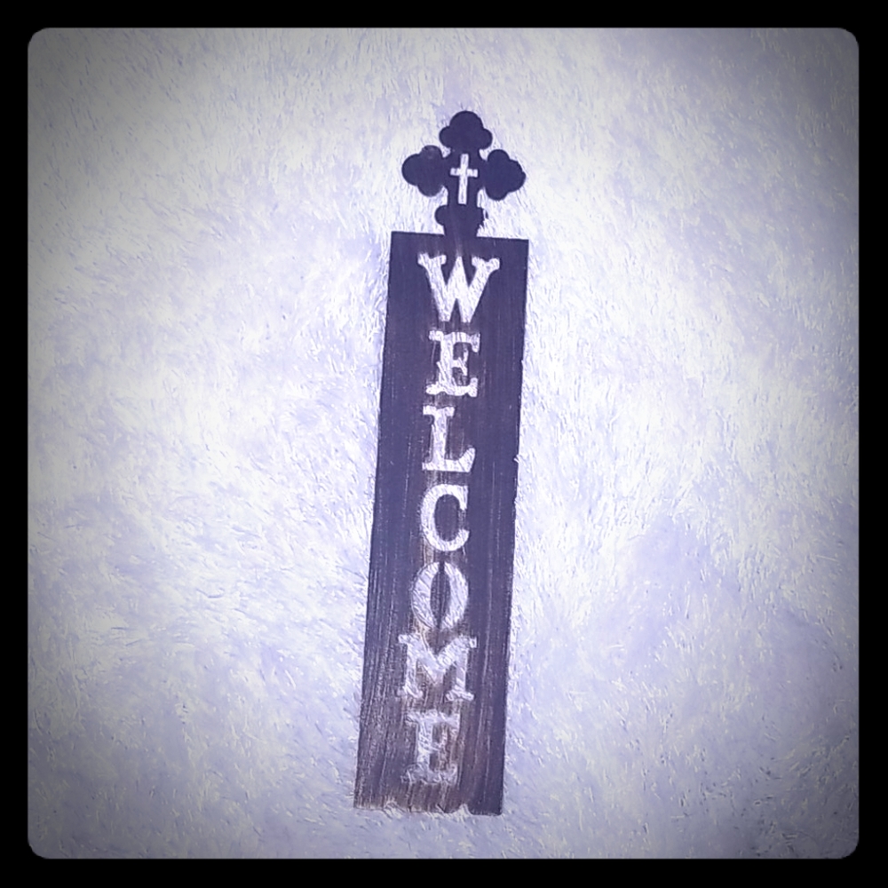 Metal welcome sign with cross